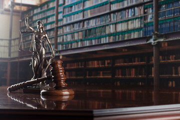 Law theme. Themis statue, scale and judge gavel in the law faculty library.