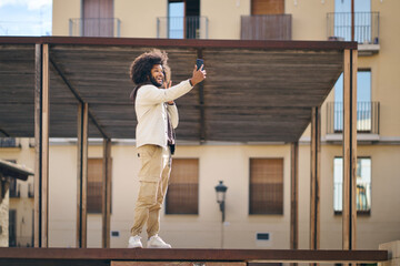 Happy young afro man taking a selfie with his mobile phone