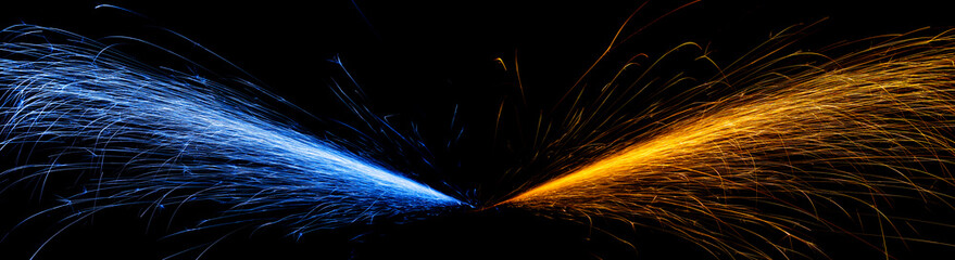 red and blue fast-flying sparks from angle grinders on black background