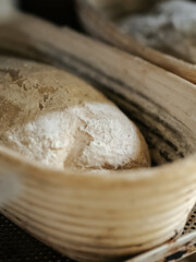 Uncooked loaves of bread in baskets before baking in a bakery close-up