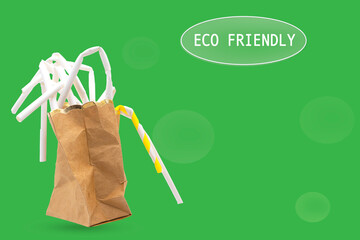 disposable paper straws in brown paper bag  isolated on green background. Eco friendly and plastic free ideal concept. 
