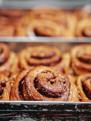 A cinnamon rolls (cinnamon bun, cinnamon swirl, cinnamon snail) close up. Fresh pastries in the bakery