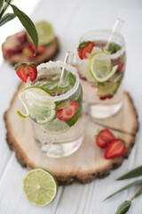 Two servings of a cooling cocktail with mint, lime and berries
