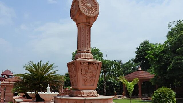 artistic red stone jain god holy pillar with bright blue sky at morning from unique angle video is taken at Shri Digamber Jain Gyanoday Tirth Kshetra, Nareli, Ajmer, Rajasthan, India.