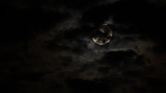 Full Moon in a dark sky on a cloudy night with flying black clouds, like in thrillers and horror films. Real shooting