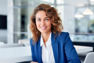 Fototapeta premium a smiling business woman is sitting at a table in an office