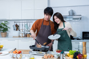 Happy of loving young asian of having fun standing a cheerful see grilled meat preparing food and...