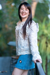 Happy of asian Portrait of people business female outside the cafe with shady trees felt like relaxing in coffee shop like the background, holiday Lifestyle