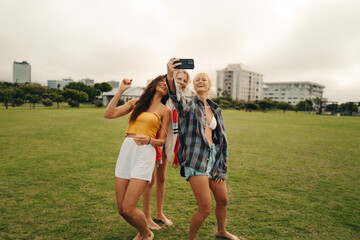 Best friends capturing fun memories with a selfie in the park