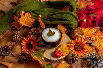 Cup of coffee with scarf, leaves and pumpkins, autumn and halloween background