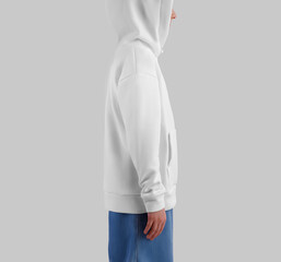 Mockup of white hoodie on blonde girl in jeans, side view, sweatshirt with hood, pocket, ties.