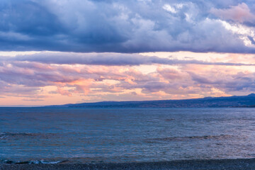 scenic blue seascape of sunset or sunrise above water with beautiful colorful evening clouds