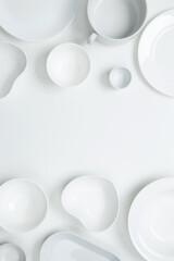 Set of different pure white dishes for home or restaurant on white background. Top view, flat lay, copy space