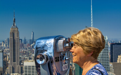 A happy elderly woman looking at New York panorama