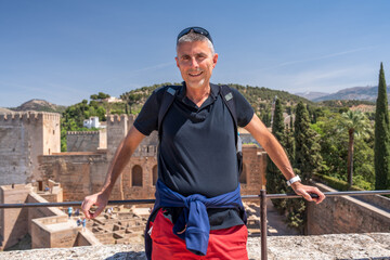 A happy male caucasian tourist visiting Alcazaba in Granada