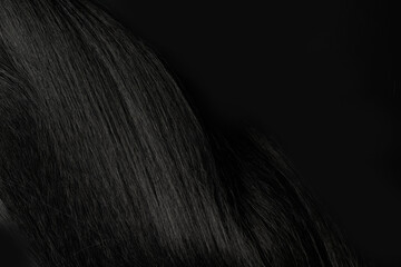 Close-up view of natural shiny dark hair, bunch of black brunette curls background