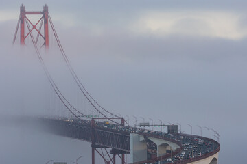 Cars driving across the bridge in the dense fog