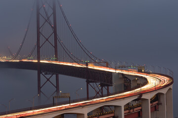 Blurred lights in motion from car headlights driving on a bridge in the evening