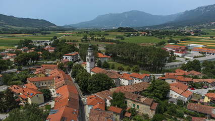 Fototapeta na wymiar Aerial View of Vipava Town, Slovenia. Red Roofs, Church, Fields and Forest Covered Hills in the Background