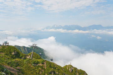 Beautiful mountain landscape with a cable car with a cabin going down the mountain with people.