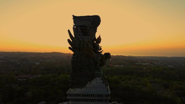 Aerial view of Bali symbol GWK statue in the park on the sunset. A huge and monumental statue located in the south of Bali. A tourist attraction and cultural asset of Bali.