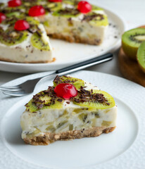 Yogurt and kiwi cake with a cookie base decorated with grated chocolate.