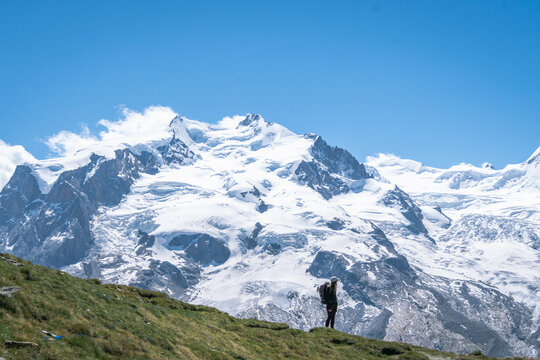 Young women embark on a thrilling alpine adventure, scaling the Swiss Alps, surrounded by awe-inspiring peaks and pristine wilderness.