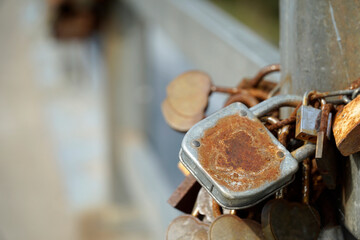 Many rusty padlocks closed on bridge fence - love concept
