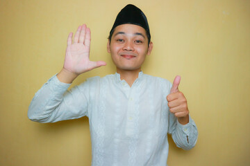 an Indonesian Muslim man of Asian descent wearing Muslim clothes and a black peci, celebrating Eid...