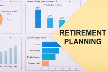 The words Retirement Planning are written on the yellow paper that is on the financial graph
