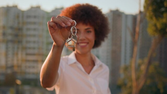 African American woman in city near building skyscraper girl outdoors dwelling accommodation female real estate agency agent showing holding bunch of key from new flat home house development apartment