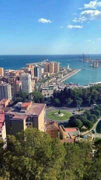 Vertical Video of coastline of Malaga city, view from above with clear blue sky. Spain.