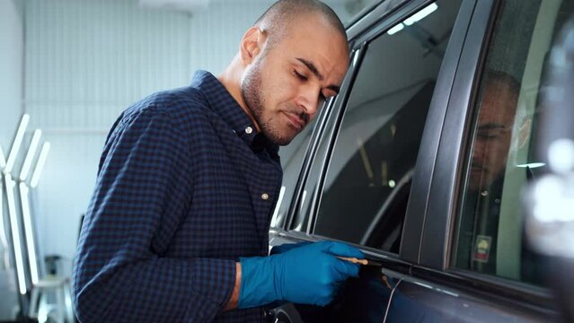 Car service master installs protective film on a car 