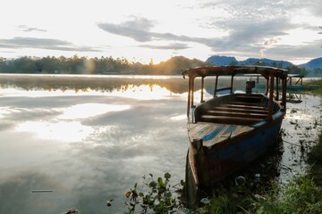 photo of dramatic sunrise view on the lake. with the boat being the foreground.