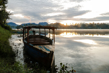 photo of dramatic sunrise view on the lake. with the boat being the foreground.