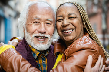 Happy multiracial senior couple portrait - Elderly people lifestyle and love relationship concept - obrazy, fototapety, plakaty