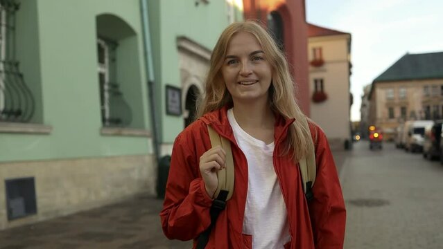 Real view of traveller woman walking on old Market Square in Krakow holding tourist map. Travel and active lifestyle concept. High quality photo. High quality FullHD footage