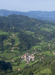 Fototapeta na wymiar Houses among green meadows, village of Regil in Euskadi, Spain