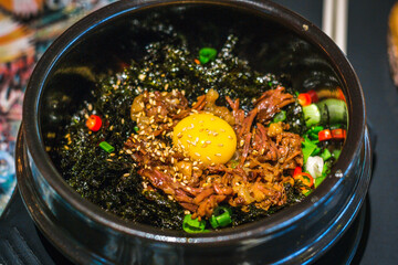 LA Galbi Beef Bowl with raw egg yolk and rice and crispy seaweed