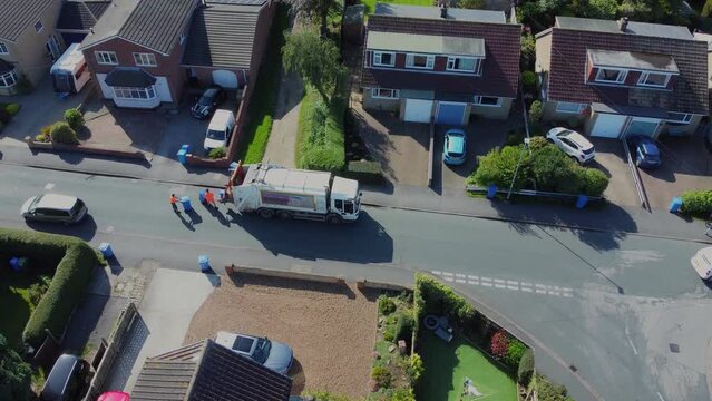 Drone. Waste collection truck in urban street collecting trash. Filmed. Yorkshire.UK. 