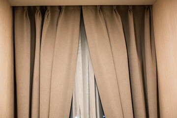Night brown curtains on the windows in the interior. White transparent day curtains and brown blackout curtains.