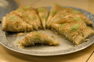 Exquisite Baklava Dessert: A plate of golden, flaky pastry layers filled with nuts, drizzled in sweet syrup.