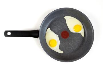 Two fried eggs in a frying pan isolated on white, top view