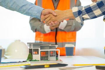 Construction engineer. businessman engineer Meet in the office to discuss building design for the client. 3rd male engineer designs house structure on table in office