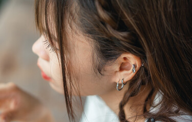 close-up of ear asian woman with earring fashion concept - obrazy, fototapety, plakaty