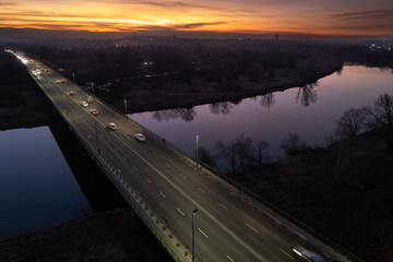 Nowa Huta Bridge (Most Nowohucki) in Krakow, Czyżyny, sunset in the city, late-night traffic, drone shot, aerial photography, aerial city view, Vistula river - obrazy, fototapety, plakaty