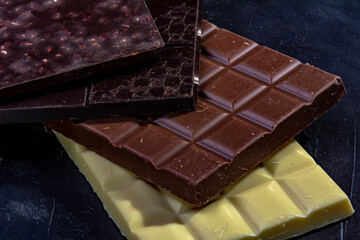 Three chocolates on dark background,