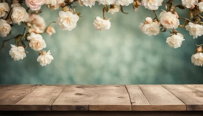 Fototapeten Vintage wooden table top with white roses and blurred blue teal background. Old wooden countertop with retro wallpaper backdrop mockup for product presentation display montage showcase advertising © Patrycja