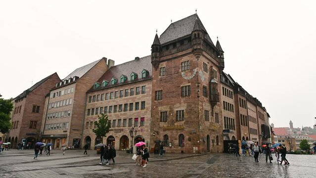 Nuremberg, Germany, August 1, 2023. Footage on a rainy day of one of the city's iconic views. In front of the church of San Lorenzo we have a magnificent example of architecture. People with umbrella.
