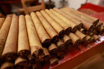 Closeup on stacked hand-rolled cigars.